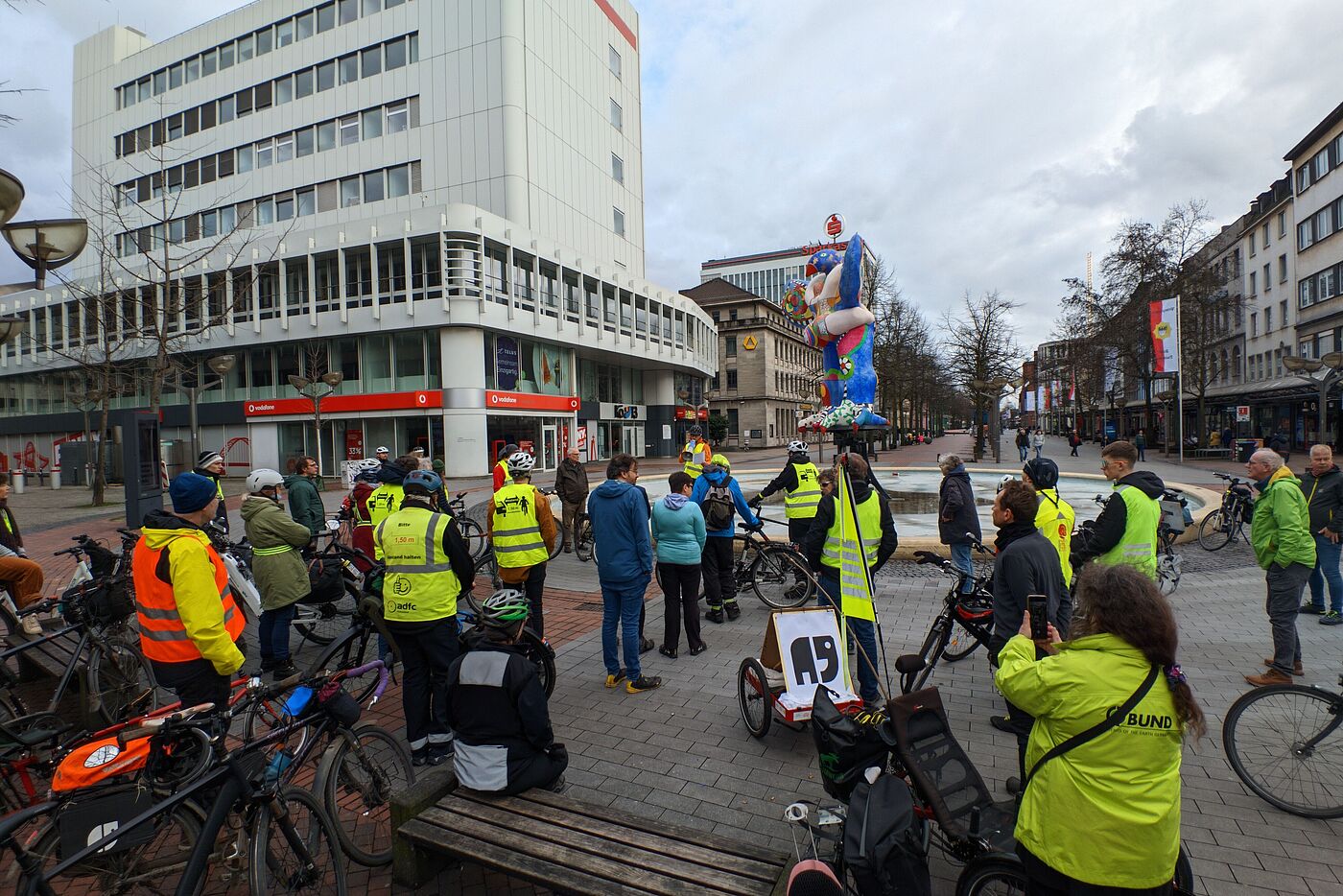 Radfahrende, die helle Fahrradkleidung tragen, treffen sich für Gedenkminute in Duisburg